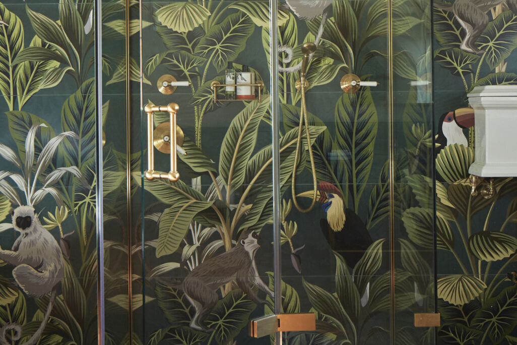 a luxury shower in bathroom with jungle print wallpaper