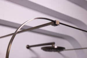 a shower head and curved shower screen close up