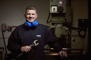a man with headphones on holding a wrench