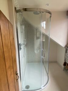 a curved shower with a glass door