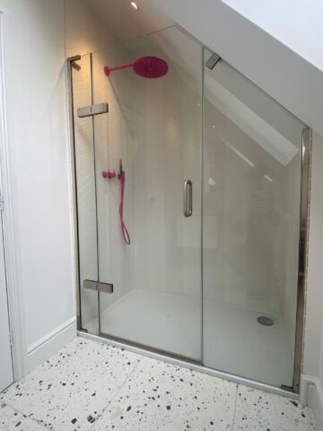 a shower with a pink shower head