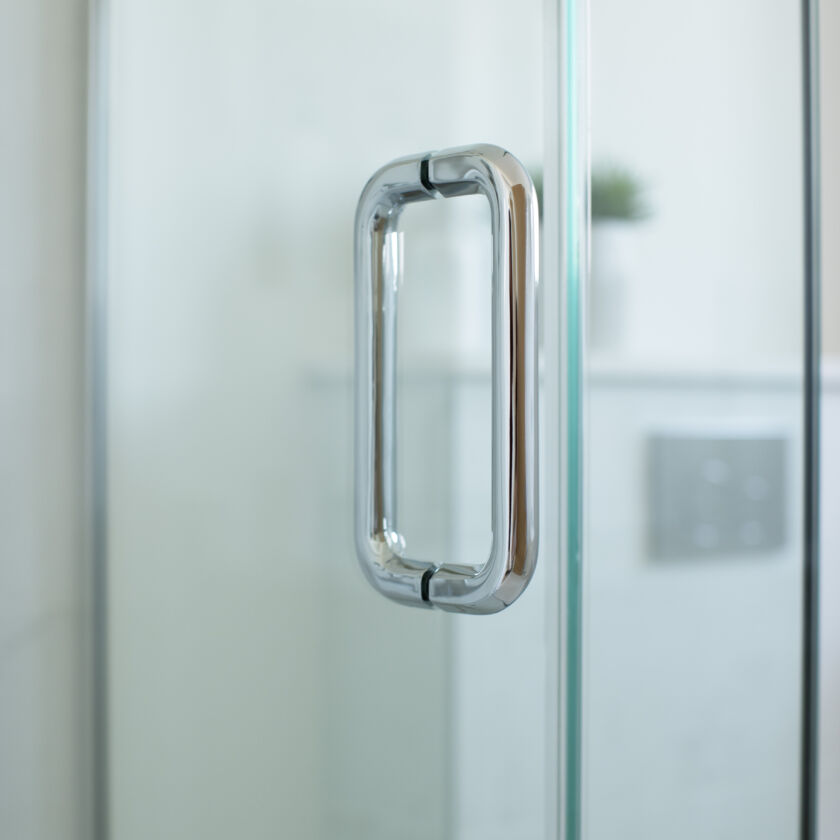 a glass shower door with a handle