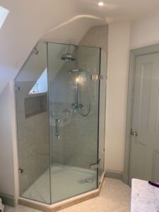 a pentagon shower with a glass door