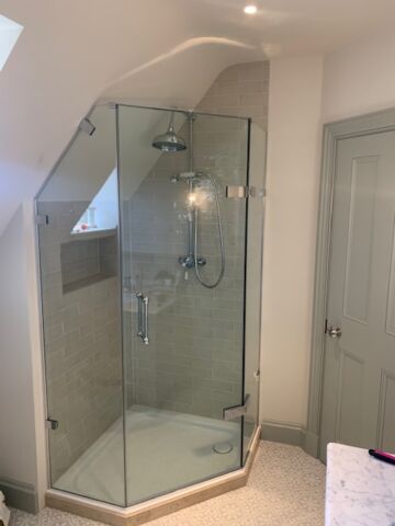 a pentagon shower with a glass door