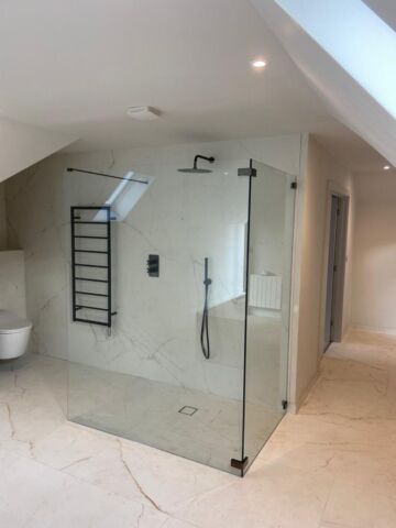 a glass shower with black hinges