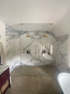 a bathroom with marble walls and double shower area