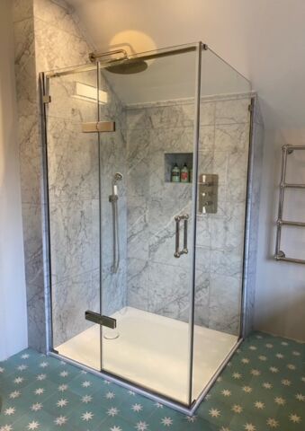 a Matki glass shower with a shower head