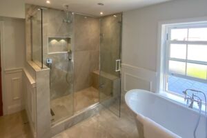a bathroom with a glass shower and bath