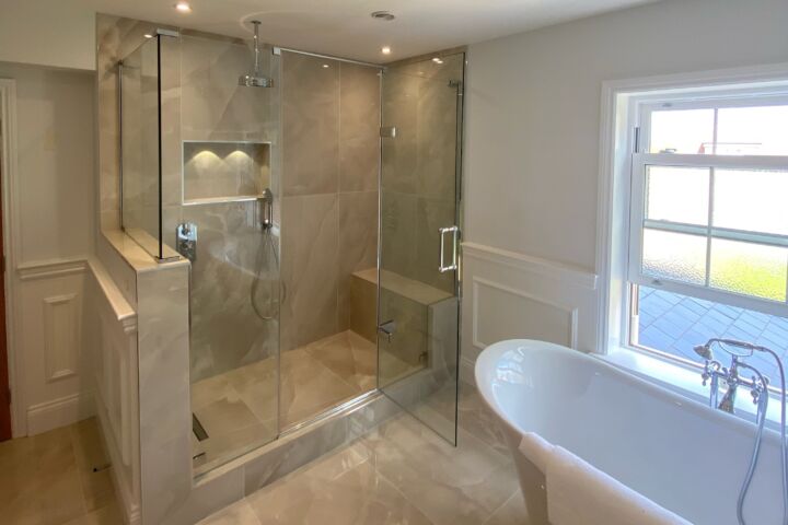 a bathroom with a glass shower and bath